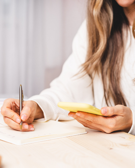 Pinterest - Frau sitzt am Tisch, mit gelbem Notizblock und macht sich Notizen