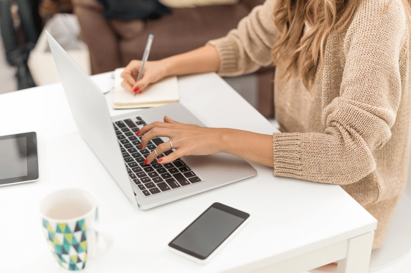 Pinterest Begriffe leicht erklärt - Frau mit Kaffeetasse sitzt vor Laptop